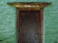 Wooden door surrounded by breathing limewash